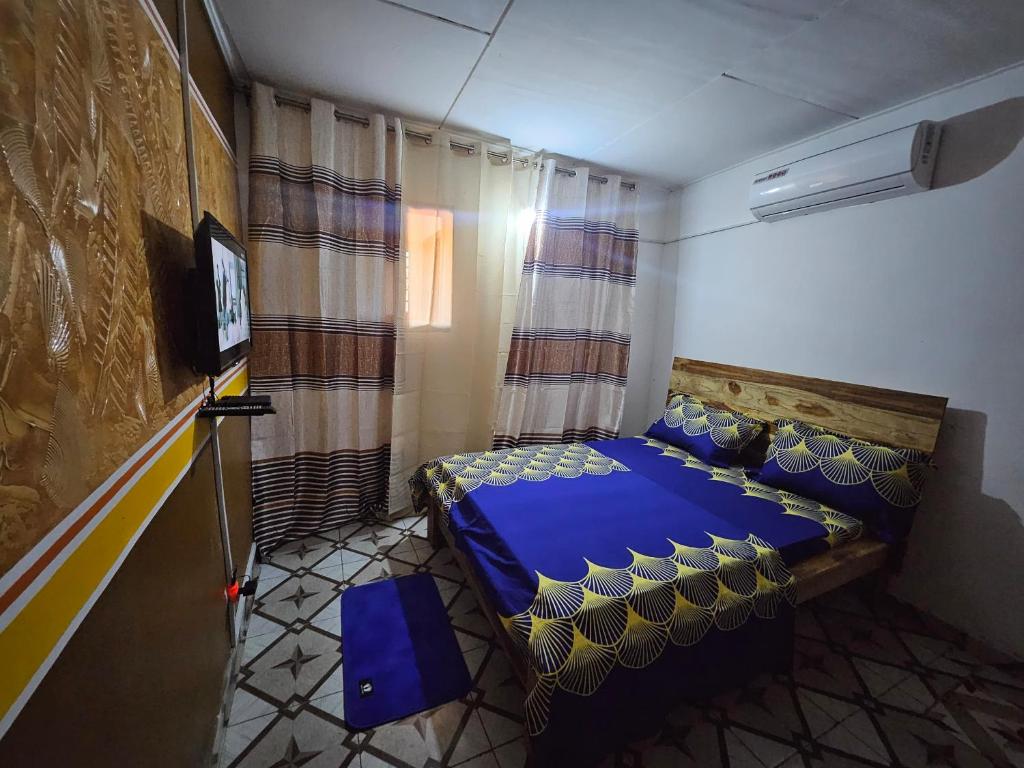 a bedroom with a blue bed and a television at Résidence BEDEL in Yamoussoukro