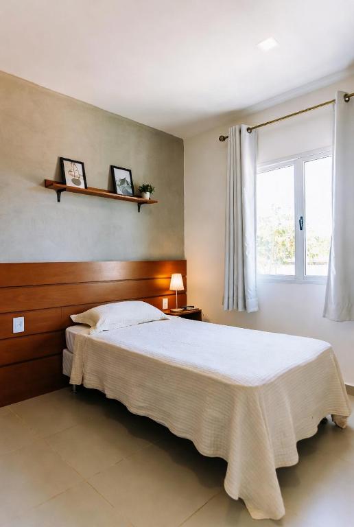 a bedroom with a large bed and a window at Hostel X20 in Arraial do Cabo