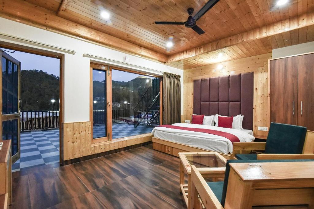 a bedroom with a bed and a balcony at Hotel Dalhousie Delight in Dalhousie