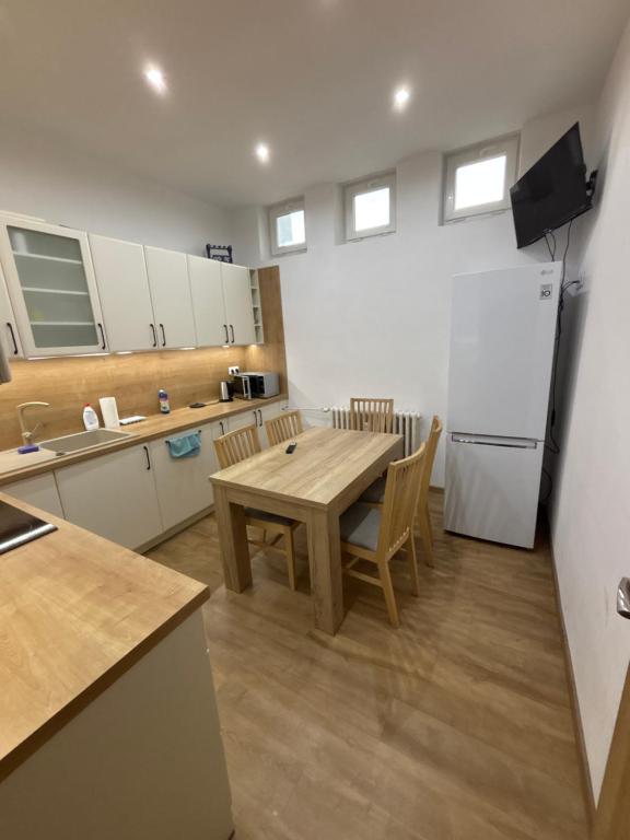 a kitchen with a wooden table and a refrigerator at Apartmán REBEKA in Holíč