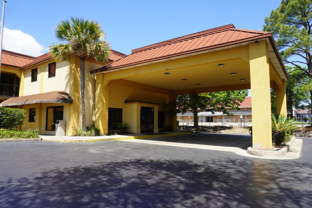 a large yellow building with a palm tree at Fairview Inn & Suites Mobile in Mobile