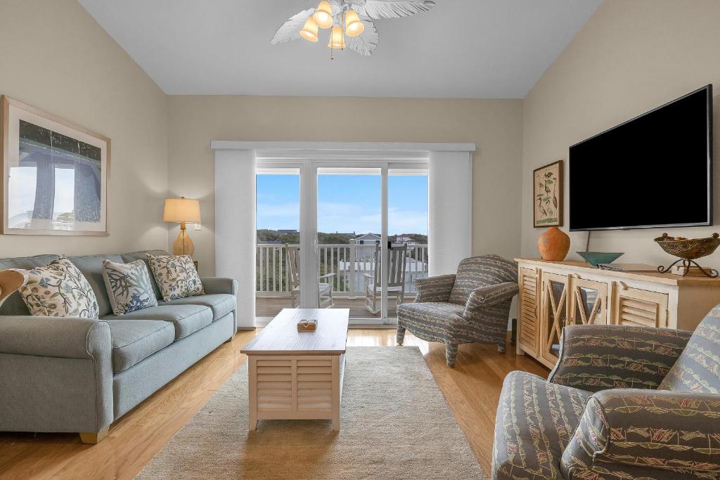a living room with a couch and a tv at Mystic Shore in Oak Island