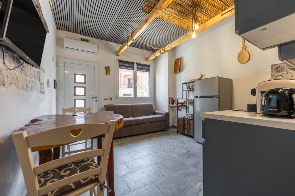 a kitchen and living room with a table and a couch at Kasa Kalagonis in Maracalagonis