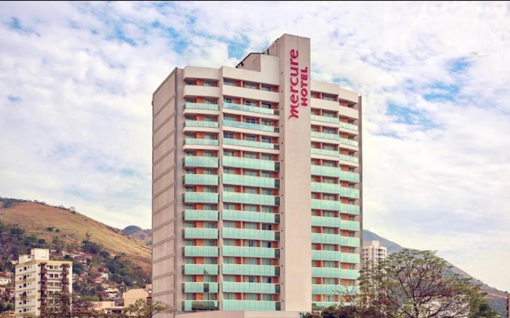 a tall building with a sign on the side of it at Flat Mercure Nova Iguaçu in Nova Iguaçu
