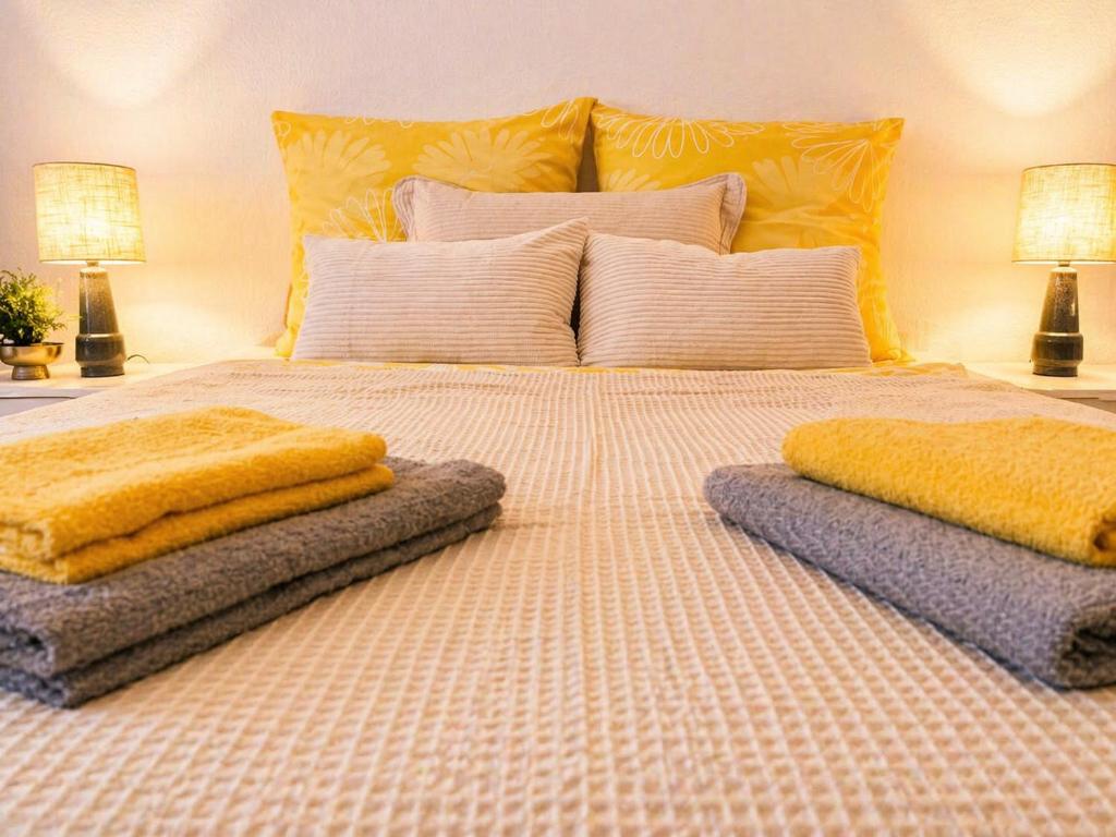a large bed with two pillows on top of it at Gemütliches Apartment am Bad Muskauer Park Sauna zu buchbar Hunde willkommen Ruhige Lage in Bad Muskau