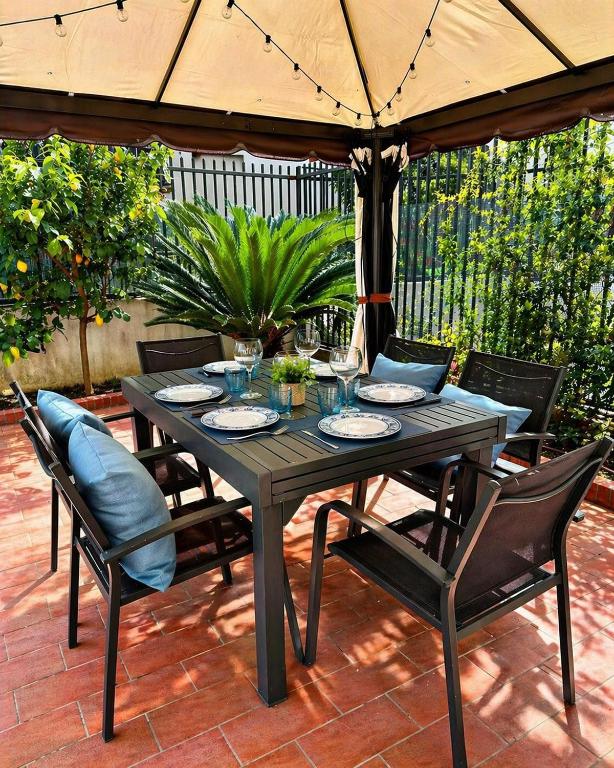 a wooden table with chairs and an umbrella on a patio at BiloVarazze with Terrace in Varazze