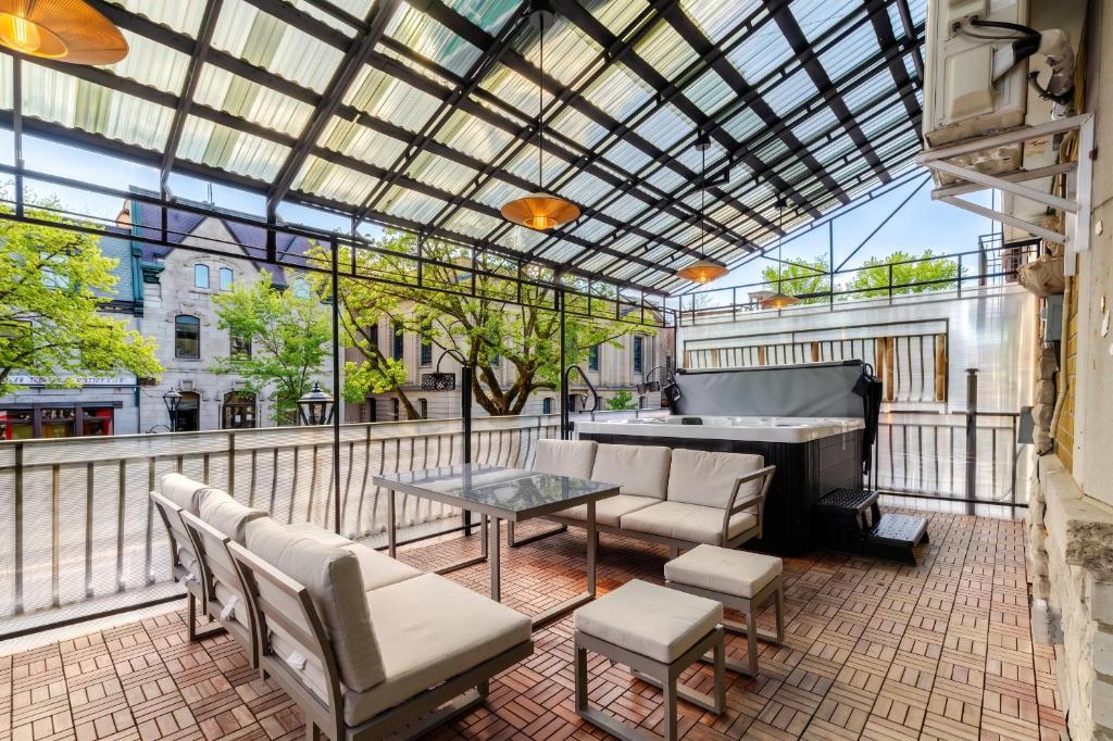 a patio with a table and a piano on a balcony at Theatre Hotel by Lodgo in Montreal