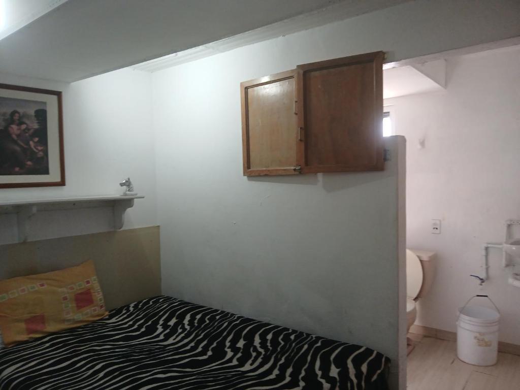 a room with a zebra print bed and a cabinet at Departamentos y Cuartos Apaxco in Apaxco de Ocampo