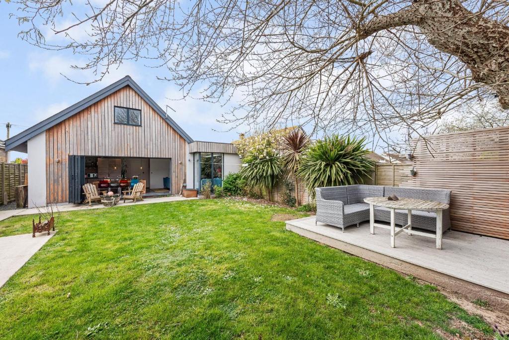 a backyard with a table and a house at Saoirse in East Wittering
