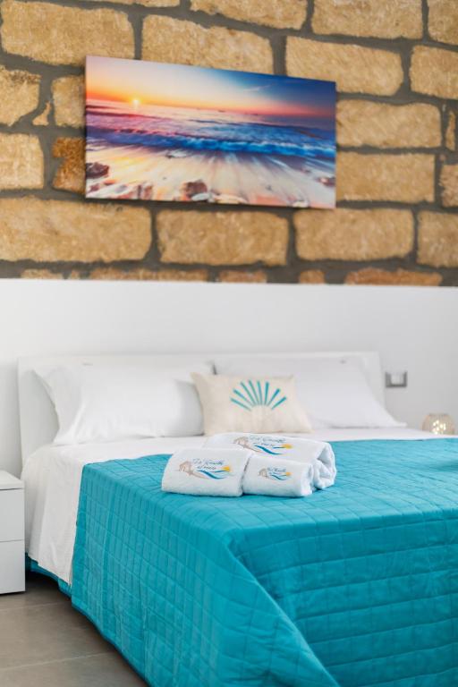 a bedroom with a blue bed with towels on it at La Casetta al mare in Balestrate