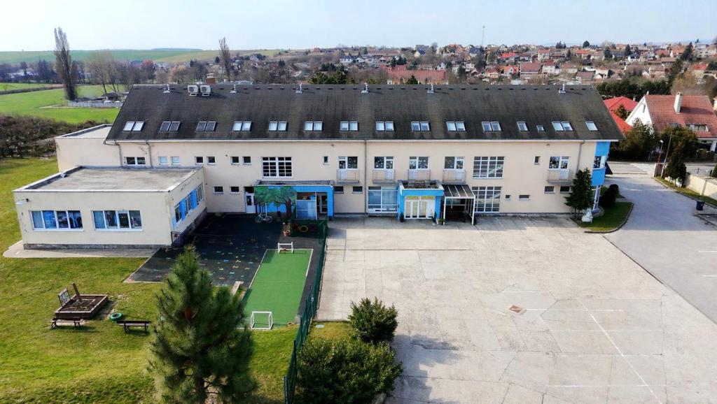 an aerial view of a large white building with a tennis court at Penzión Lindava in Budmerice