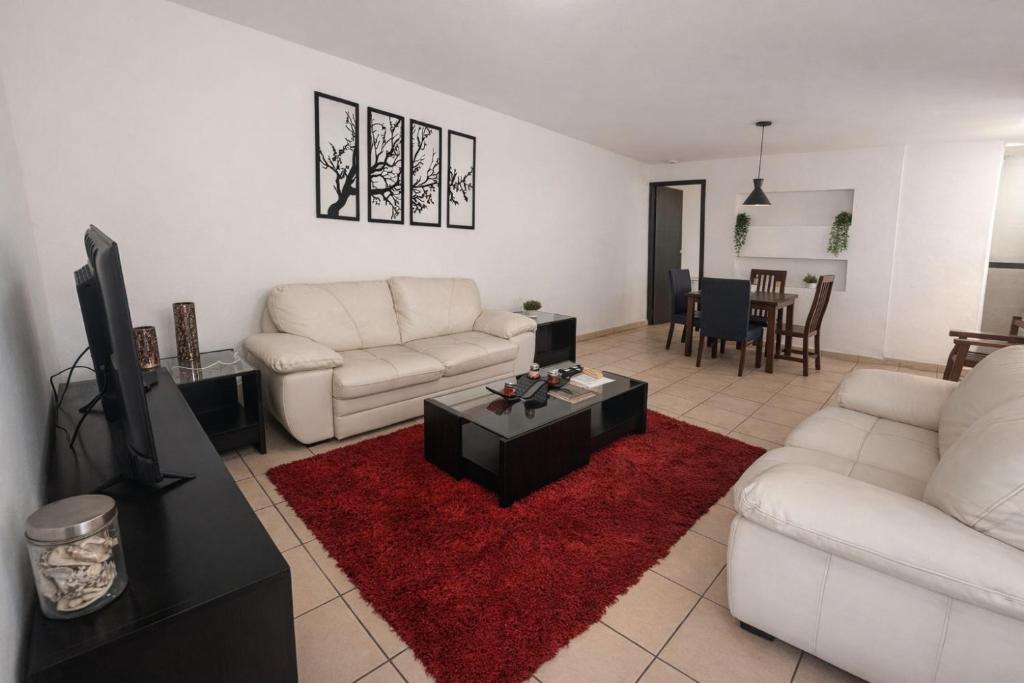 a living room with white couches and a red rug at Rinconcito de Paz en Xalapa in Xalapa