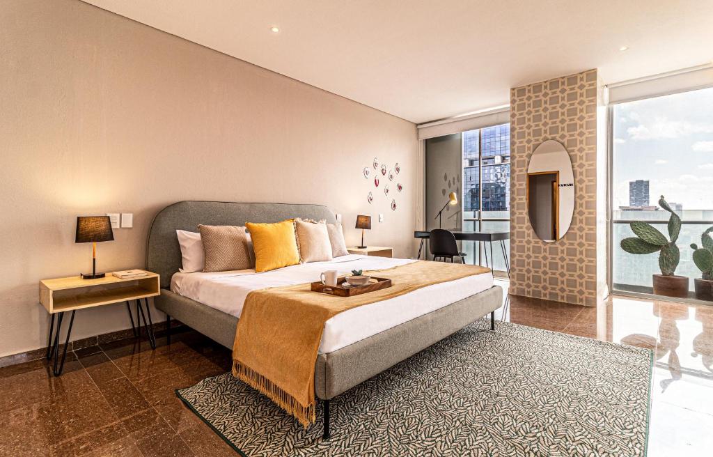 a bedroom with a large bed and a large window at Casa Reforma by Kukun in Mexico City