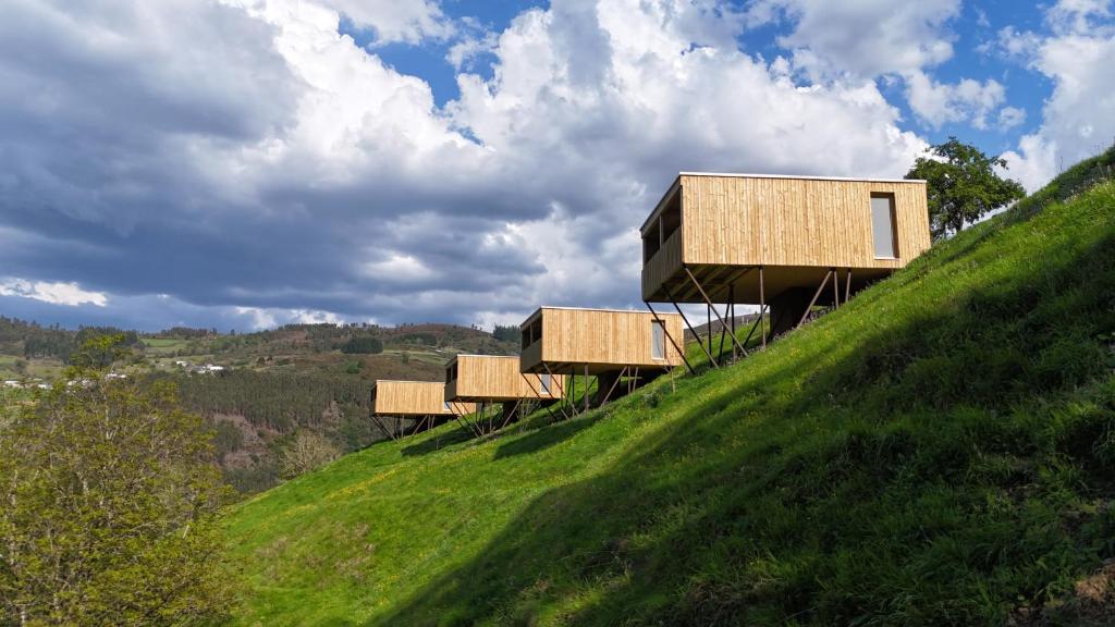 a house on top of a grassy hill at Cabanas do Navia in Coea