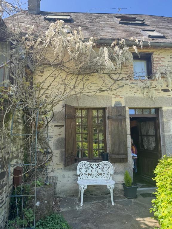 a white bench sitting outside of a house at La poésie de l'instant in Bétête