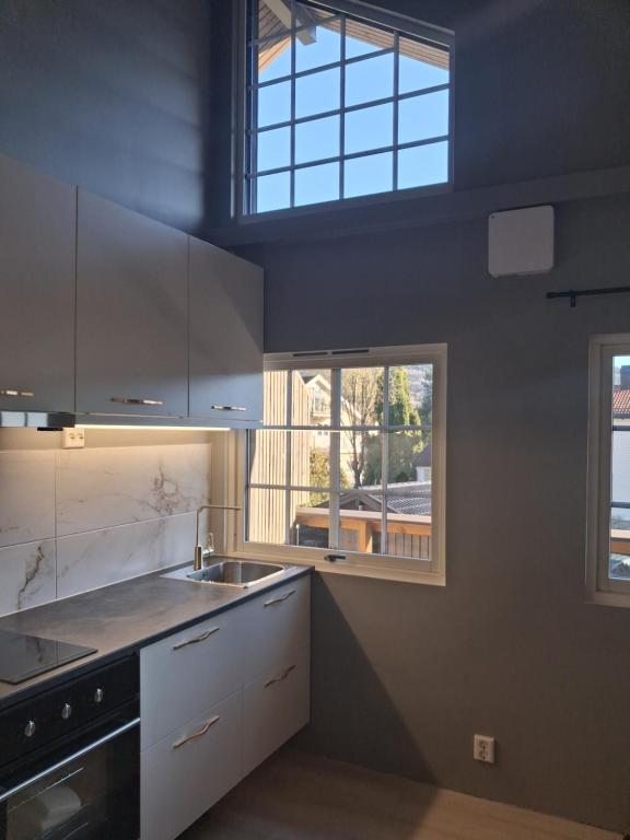 a kitchen with a sink and a window at Øren modern apartment in Drammen
