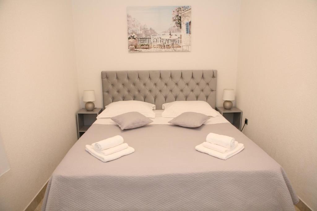 a bedroom with a bed with two white towels on it at Apartments Old Town in Trogir