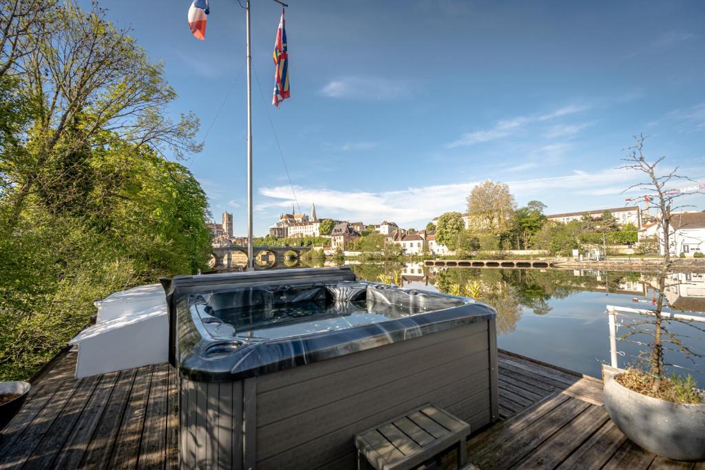a small boat sitting on a dock next to a body of water at Ainos Louanges - Bail Partner in Auxerre