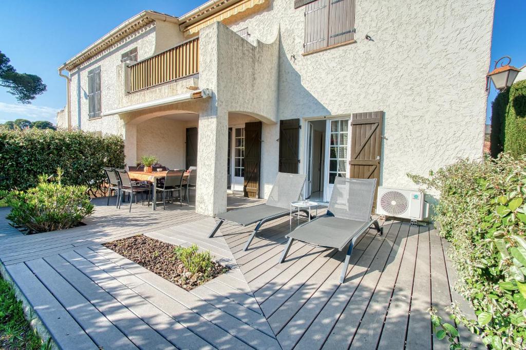 a patio with chairs and a table in front of a house at Le Charme bleu d'Azur in Saint-Raphaël