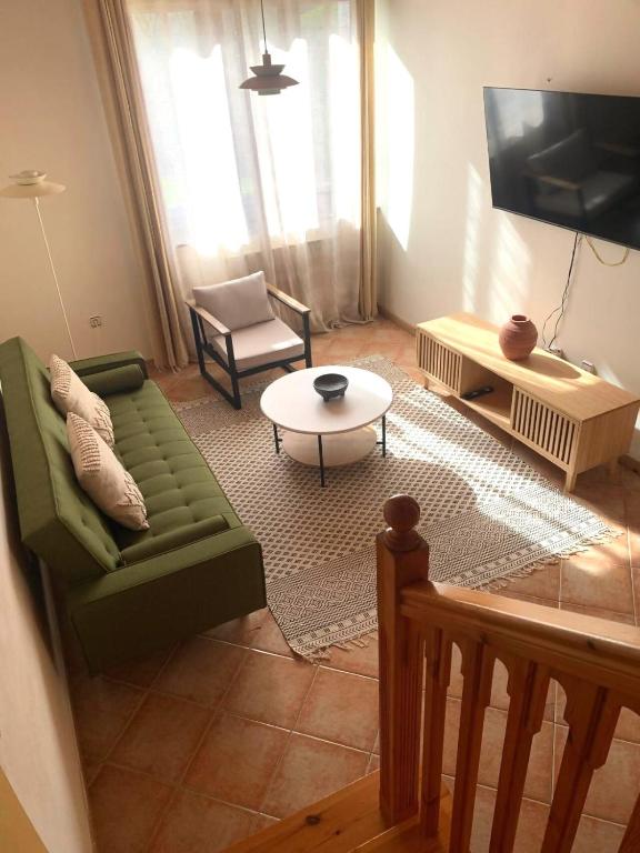 a living room with a green couch and a table at Escuelas de collía A AT-1537-AS in Arriondas