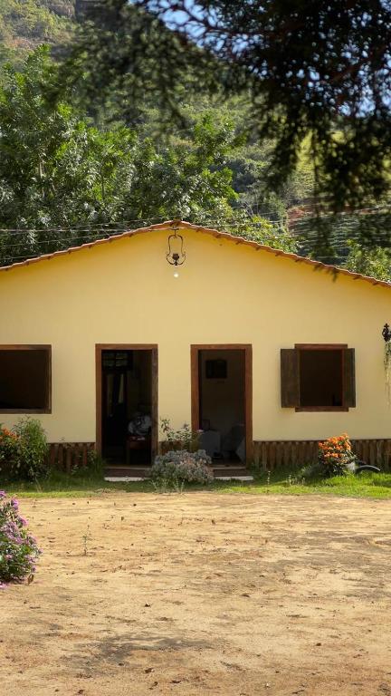 a yellow house with two doors and a yard at Pousada Ferrari Casa Nostra in Santa Teresa
