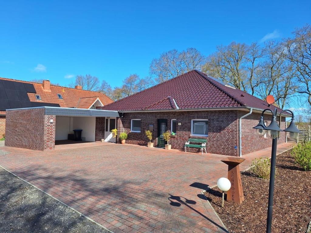 a brick house with a brick driveway at Huus 8 in Westoverledingen