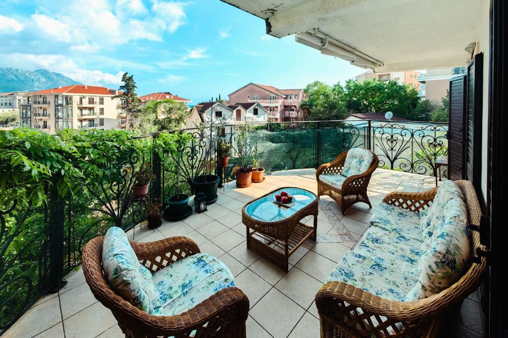 a patio with chairs and a table on a balcony at Paradise Garden Villa in Bečići