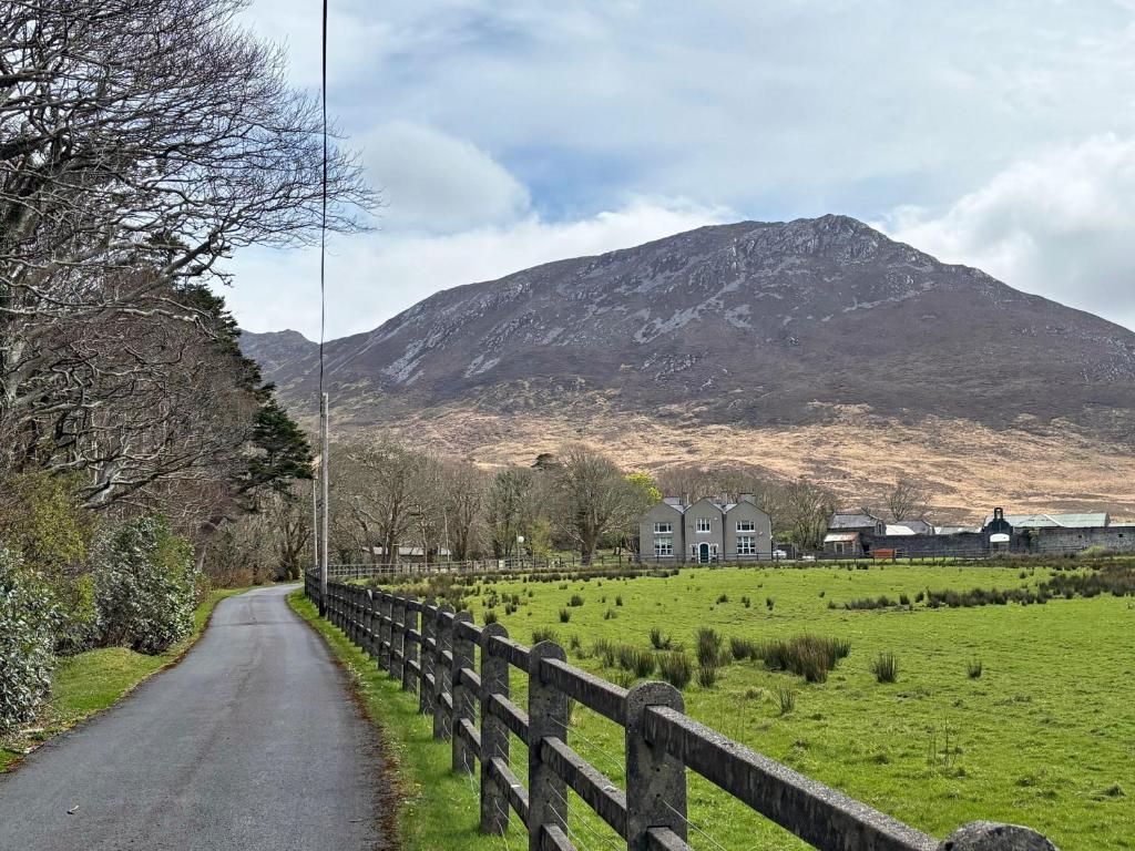a road with a fence and a mountain in the background at Property 472 - Kylemore in Kylemore