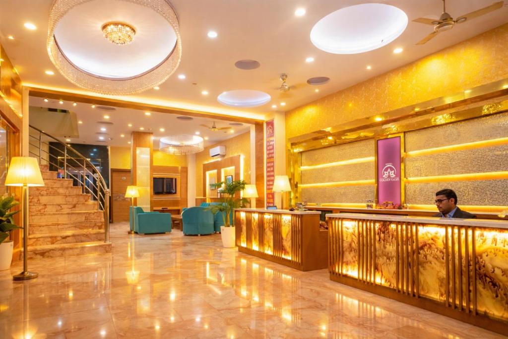 a lobby of a hotel with a man sitting at a bar at Hotel Golden Oasis - 5 Minute Walk from New Delhi Railway Station in New Delhi