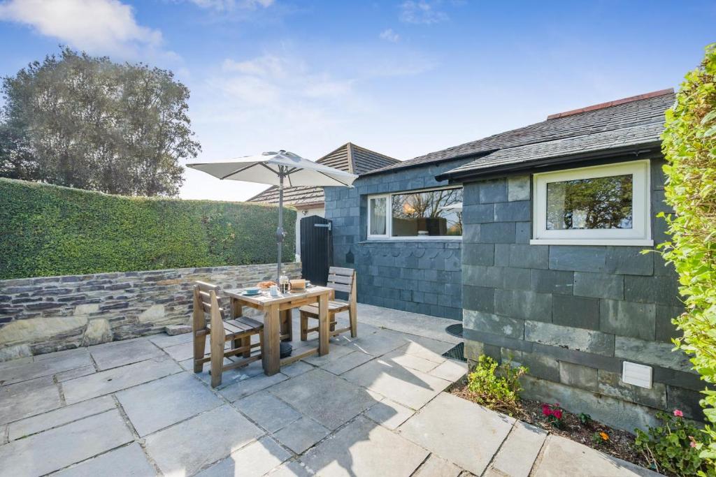 a patio with a table and an umbrella at 1 Bed in Padstow oc-p00554 in Saint Merryn