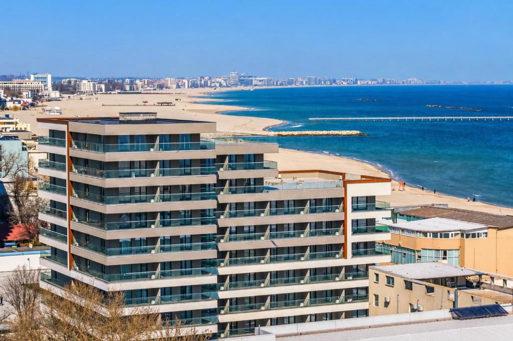 a large building with a beach in the background at Crystal by Solid Sea View Mamaia - Apartament langa plaja cu vedere la mare in Mamaia