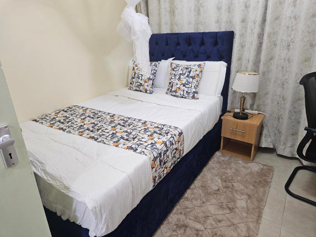 a bedroom with a bed with a blue headboard at Favoured Brink in Nairobi