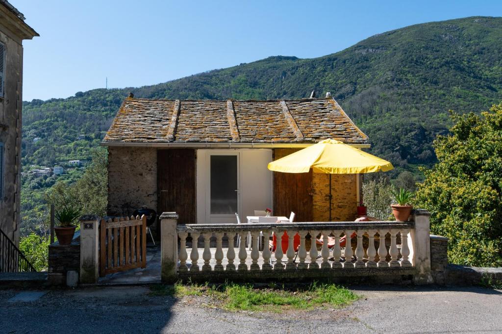 a small house with an umbrella and a table at Maisonnette Chez Aurèle in Santa-Maria-di-Lota