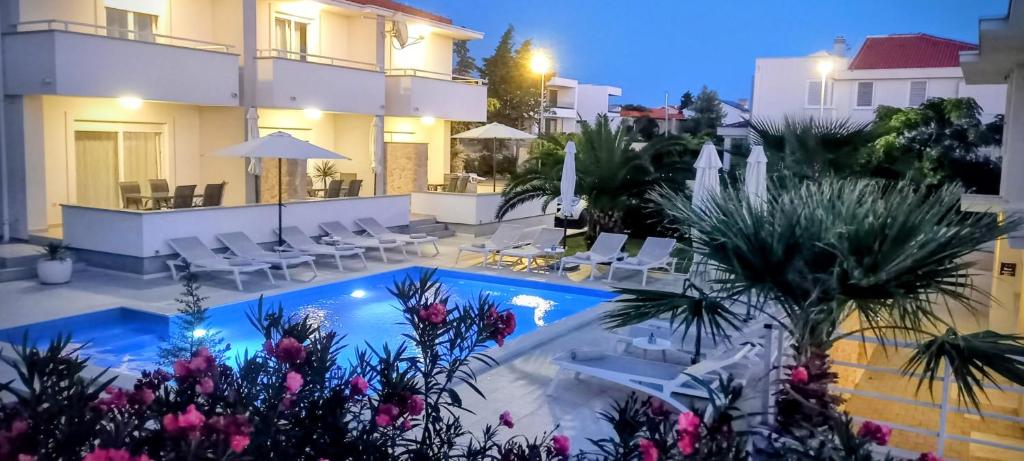 a hotel with a swimming pool at night at Luxury apartments Cuba in Novalja