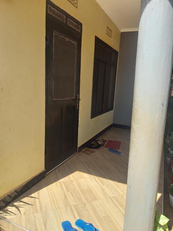 an empty room with a door and a wooden floor at Cae Cozy Home in Karatu