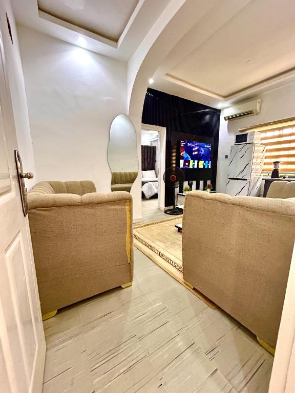 a living room with two couches and a tv at Saint Apartment by Bento in Gwarinpa