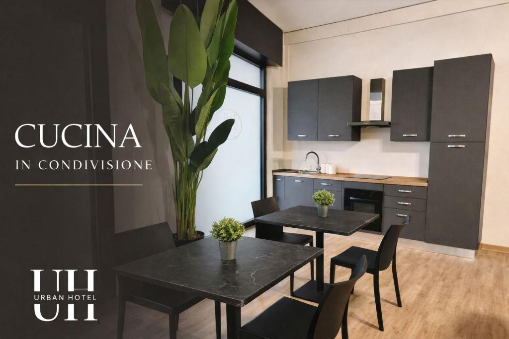 a kitchen and dining room with two tables and chairs at Urban Hotel in Cesena
