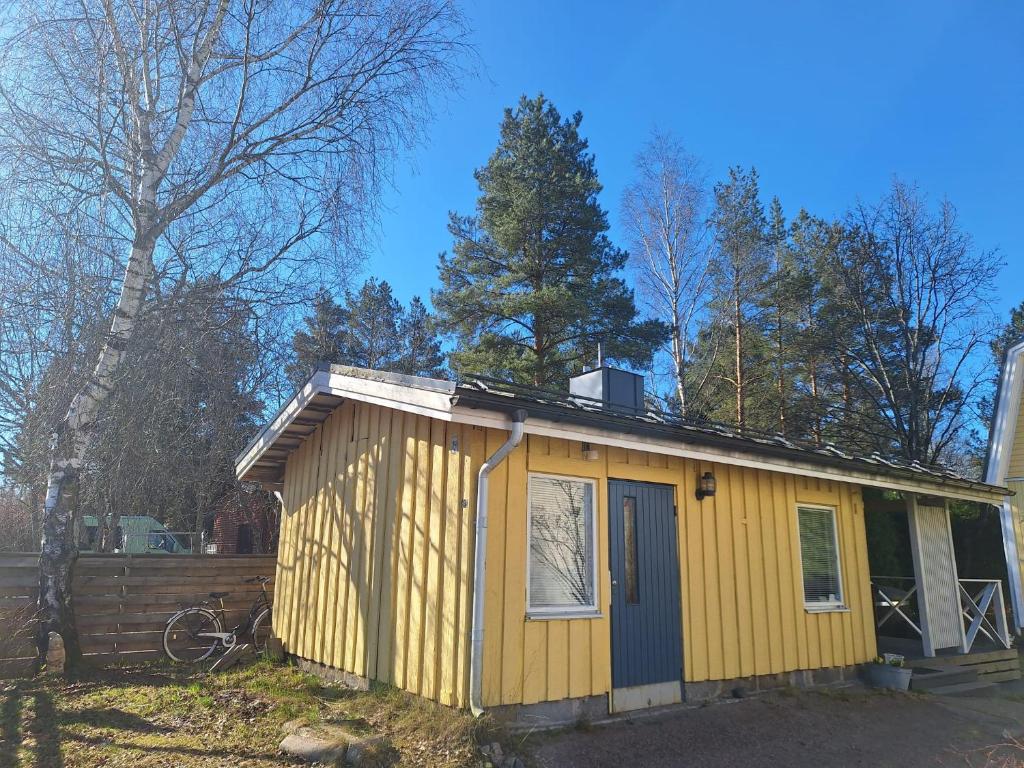 a yellow tiny house in a yard at Saunamökki in Helsinki