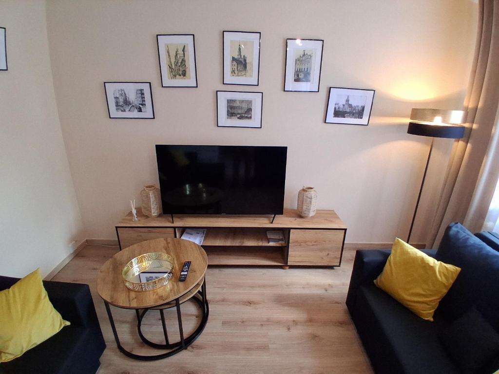 a living room with a television and a coffee table at Umińskiego Spacious Apartment in Poznań