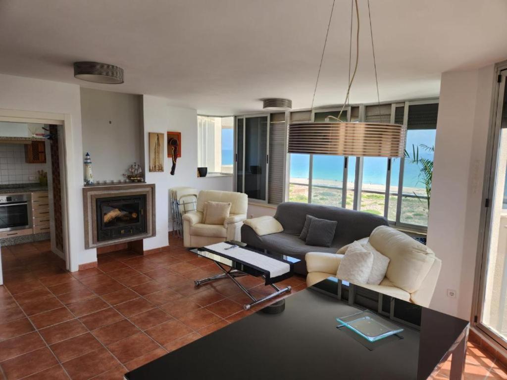 a living room with a couch and a fireplace at Three Horizons Penthouse El Saler in Valencia