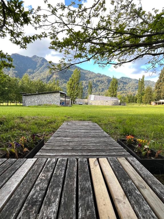 a wooden bench sitting on top of a field at El Descanso del Quijote in Riñinahue