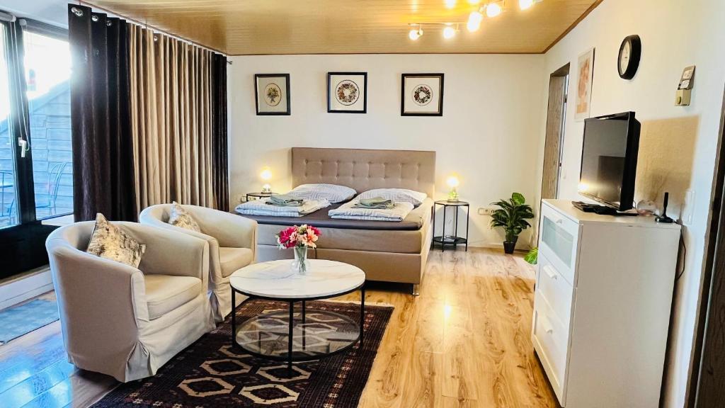 a small living room with a bed and a table at Private Studio Apartment with Balcony in Dortmund-Brackel in Dortmund