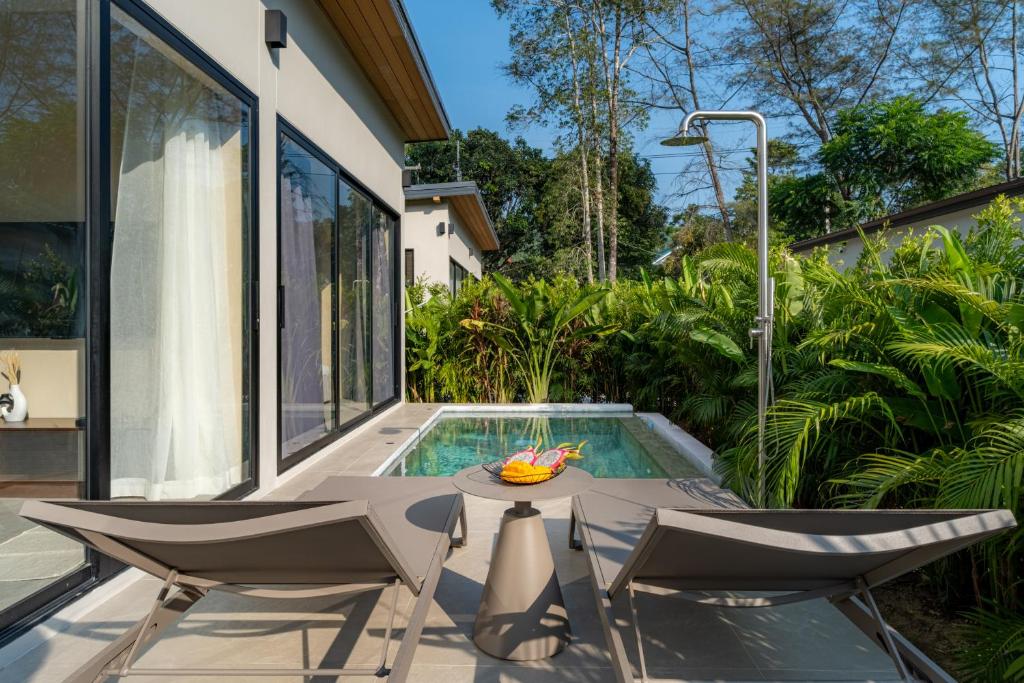 a patio with a table and chairs next to a swimming pool at Demaya Villa 5 in Ko Phangan