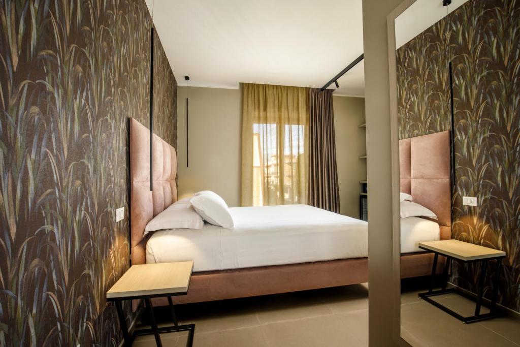 a bedroom with a large bed and two tables at Fly Suite Rome Airport in Fiumicino