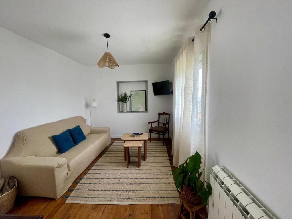 a living room with a couch and a table at Raízes da Serra - Casa Lapa in Lapa dos Dinheiros