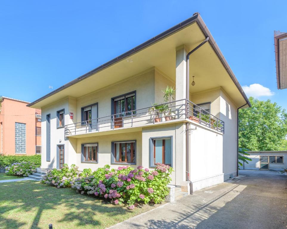 a white house with a balcony and some flowers at Scenarium in Udine