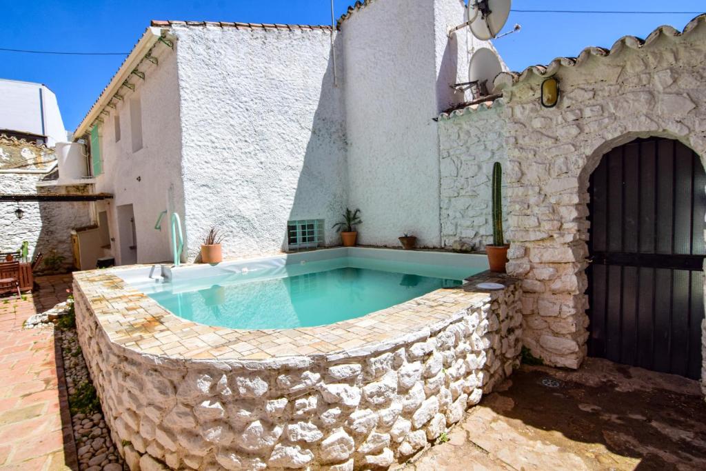 a pool in a stone wall around a house at La Calma de Vilo in Periana
