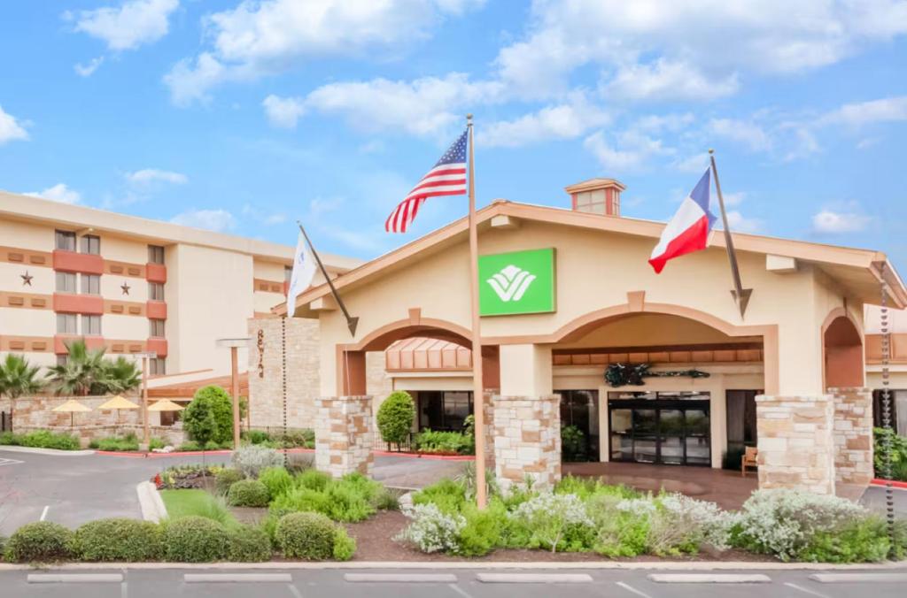 a hotel with flags in front of a building at Wyndham Garden Hotel Austin in Austin