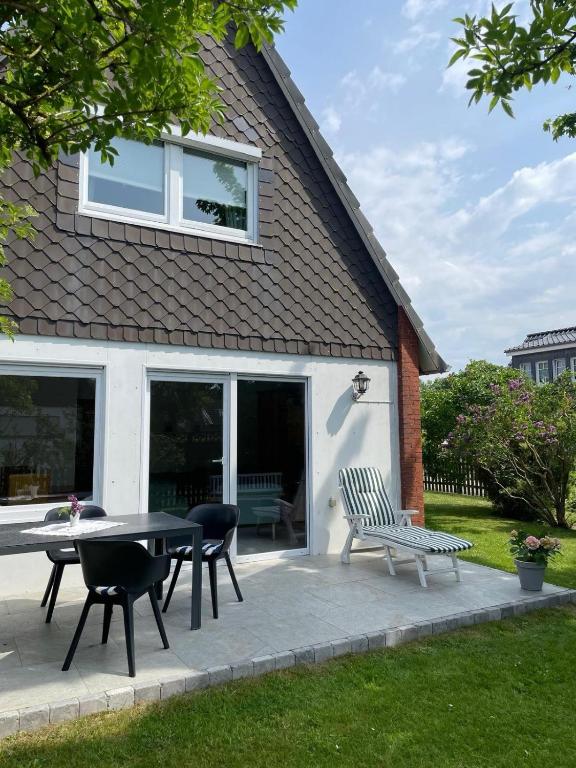 a patio with a table and chairs in front of a house at Ferienhaus Familie Lehmann in Borkum