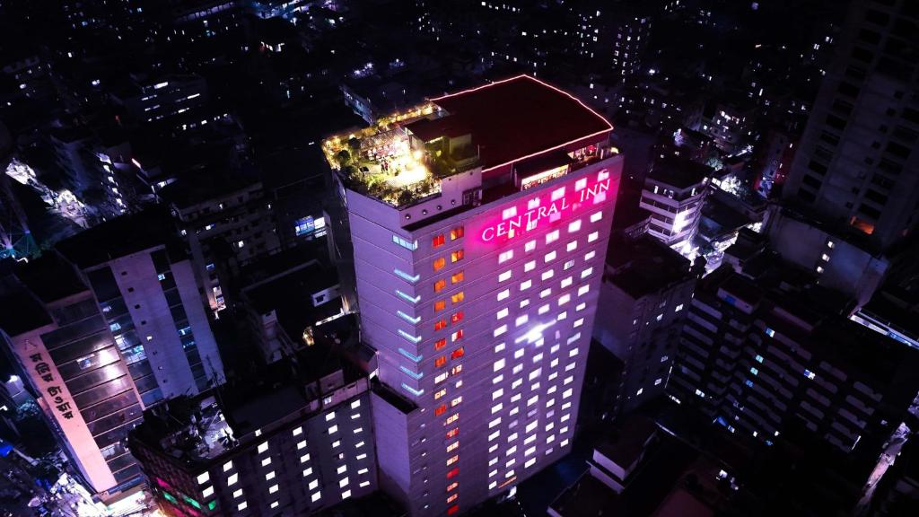 a tall building with a sign on top of it at night at Central Inn Hotel & Spa in Dhaka